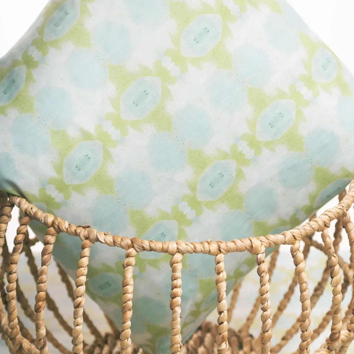 Luxury decorative pillow featuring an abstract small repeat pattern in chartreuse green and soft blue tones, styled for a layered modern traditional interior.